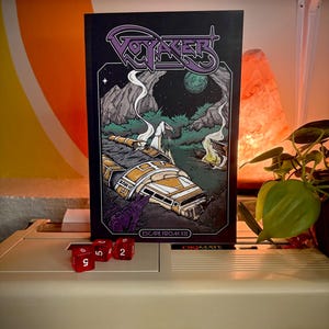 May include: A rectangular book titled Voyager Escape From X8 with a black cover featuring a purple logo and a detailed illustration of a crashed yellow and white spacecraft in a dark, rocky landscape with a green moon and a purple creature.