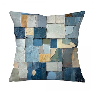 May include: Square throw pillow with a patchwork design in shades of blue, gray, and beige. The pillow's surface is divided into irregular rectangular blocks, creating a textured, abstract pattern. The design has a distressed, aged appearance.