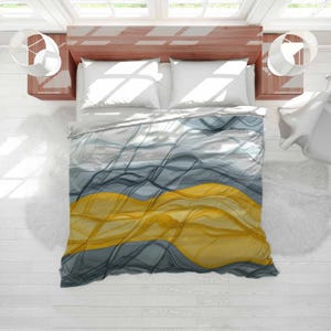 May include: A bed with a duvet cover featuring an abstract design of flowing lines in grey, blue, and yellow. The bed has white pillows and a light wood headboard. The room has white walls and floors. The duvet cover design is reminiscent of waves.