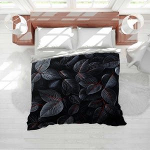May include: A black and grey duvet cover with a repeating pattern of large leaves with red veins. The leaves have a detailed, textured appearance, creating a striking contrast against the dark background. The bedding is on a wooden bed frame.