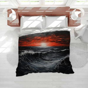 May include: A bedding set featuring a dramatic ocean scene with a fiery red sunset over dark waves. The duvet cover and pillows are on a wooden bed frame, creating a striking contrast. The artwork evokes a sense of power and natural beauty.