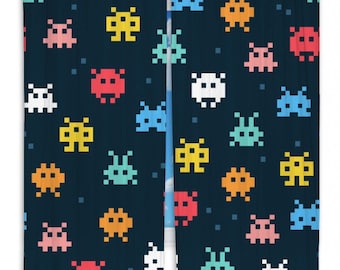 May include: A pair of dark blue curtains with a repeating pattern of colorful pixelated space invaders. The space invaders are in various colors, including red, orange, yellow, green, blue, and white.
