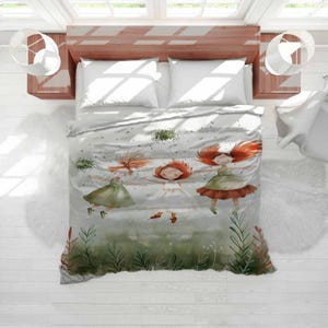 May include: A duvet cover featuring a whimsical illustration of three girls with flowing red hair and dresses in shades of green and brown. The design includes a soft, watercolor-style background with green foliage and a light gray sky.