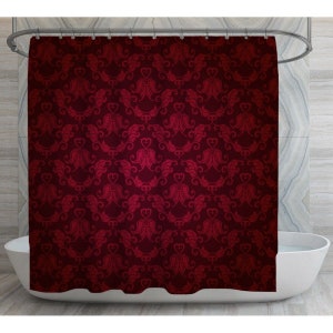 May include: Red shower curtain with a damask pattern. The pattern features intricate floral designs and hearts.