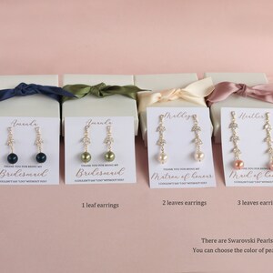 May include: Four white gift boxes with gold lettering and a pair of gold earrings with a pearl and crystal leaves in each box. The boxes are labeled "Bridesmaid", "Bridesmaid", "Matron of Honor", and "Maid of Honor". The text "There are Swarovski Pearls. You can choose the color of pearls" is at the bottom of the image.