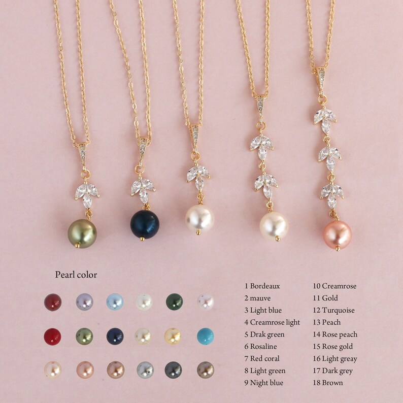 May include: A set of 18 gold necklaces with a leaf design and a pearl pendant. The pearls are in various colors, including green, blue, white, peach, and pink.