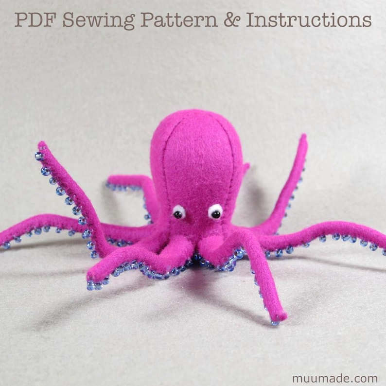 A felt pink octopus with blue beads (suction cups or suckers) on its eight bendy arms