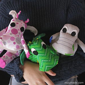 Three soft fabric plushies, all from the same set of sewing patterns: one T-rex dinosaur and two dragons. Their sewing patterns & instructions set is available for instant download from muumade.etsy.com.