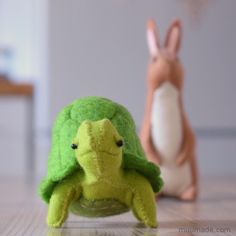 A green felt turtle and a brown rabbit behind him. Their sewing patterns & instructions are available separately for instant download from muumade.etsy.com.