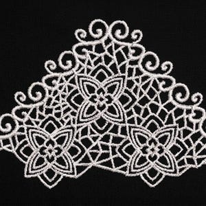 May include: White lace applique with a floral and geometric design on a black background. The delicate embroidery features three central flower shapes and a decorative border with swirling details. This textile art piece is suitable for various craft projects.