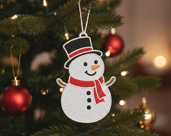 May include: Embroidered snowman Christmas ornament. The snowman has a black top hat with a red band, a red scarf, and black button eyes and mouth. The ornament is hanging on a Christmas tree with red and gold ornaments.
