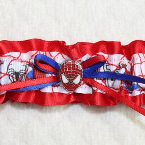 May include: Red and blue garter with a white spider-man design and a spider-man button.