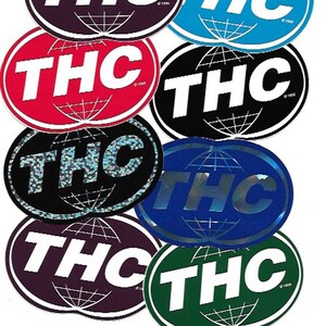 May include: A collection of ten oval stickers with the word "THC" printed in white on a variety of coloured backgrounds. The stickers feature a globe design with lines radiating from the centre.