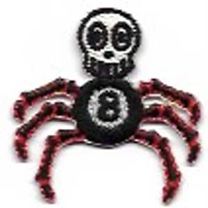 Peut inclure: Un crâne noir et blanc avec une boule noire numéro huit au centre, avec des pattes d'araignée rouges et noires.