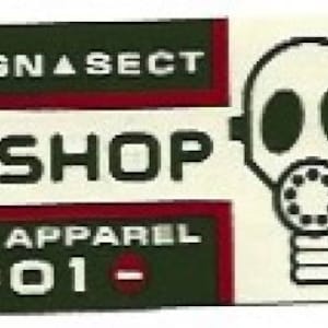 May include: A rectangular sticker with the words "SOVEREIGN SECT WORKSHOP SURVIVAL APPAREL + 2001 -" in white text on a dark green and red background. A gas mask graphic is on the right side.