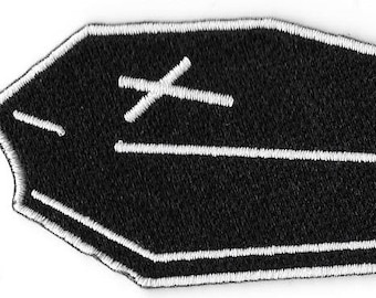 Pode incluir: Patch bordado preto e branco em forma de caixão com uma cruz branca no topo.