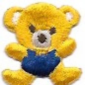 May include: A yellow plush teddy bear wearing a blue overall. The bear has a brown nose and black eyes.