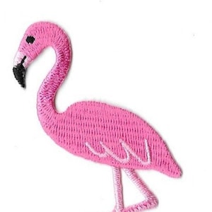 May include: Pink flamingo embroidered patch. The flamingo is standing on one leg with its neck curved.