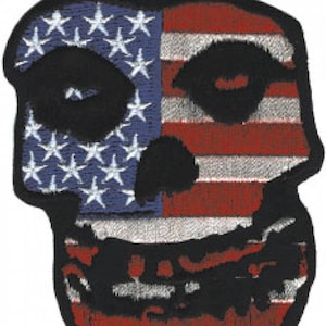 Könnte beinhalten: Ein gestickter Aufnäher mit einem Totenkopf im Design der amerikanischen Flagge. Der Totenkopf ist schwarz und die Flagge ist rot, weiß und blau.
