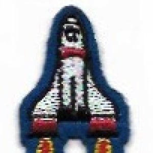 Könnte beinhalten: Eine blaue und weiße Rakete mit roten Akzenten und gelben Flammen. Die Rakete ist ein Patch oder ein Bügeleisen-Aufkleber.