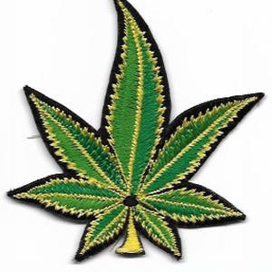 Puede incluir: Parche bordado de hoja de marihuana verde y amarilla. La hoja está bordeada de negro.