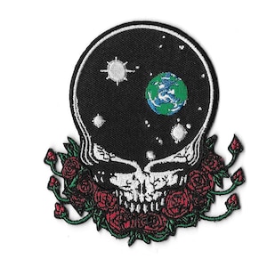 May include: Embroidered patch featuring a skull design with a black background depicting a starry sky and a green and blue planet. The skull is surrounded by red roses with green leaves. The patch has a white border.