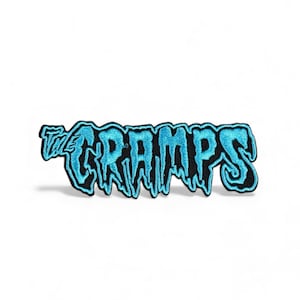 May include: Embroidered patch with the text "The Cramps" in a dripping, stylized font. The design features bright blue lettering with a black outline. Suitable for application on clothing or accessories.