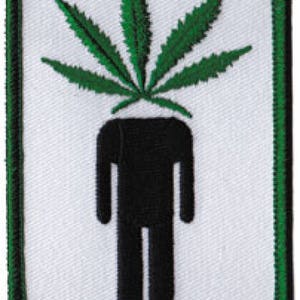 Puede incluir: Una hoja de marihuana verde con una silueta de figura de palo negra debajo. La imagen está sobre un fondo blanco con un borde verde.