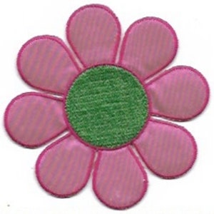 Könnte beinhalten: Eine rosa Filzblume mit einem grünen Filzmittelpunkt. Die Blume hat sieben Blütenblätter und ist etwa 7,5 cm im Durchmesser.