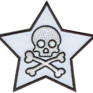 Może przedstawiać: Biała naszywka haftowana w kształcie gwiazdy z motywem czaszki i skrzyżowanych kości. Czaszka i skrzyżowane kości są białe z czarnymi konturami.