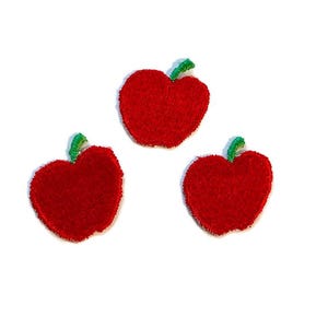 Puede incluir: Tres parches de manzana de fieltro rojo con tallos verdes.