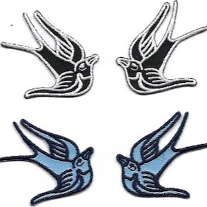 Puede incluir: Dos pares de parches para planchar con un diseño de golondrina estilizado. Un par es negro con contornos blancos, y el otro par es azul con contornos negros.