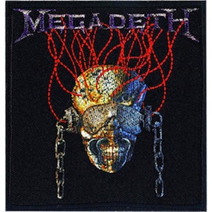 Puede incluir: Parche bordado negro con el nombre de la banda "Megadeth" en letras blancas. El parche presenta una calavera con una cadena y cables rojos.