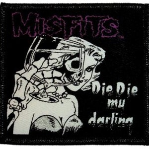 May include: Black and white patch with the band name "Misfits" in purple lettering. A woman with a skull face is holding a glass of wine. The text "Die Die My Darling" is below the woman.