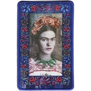 May include: A blue embroidered patch with a portrait of Frida Kahlo in a floral frame. The frame is decorated with red, purple, and green flowers.