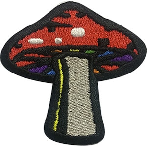 May include: A colourful embroidered iron-on patch of a mushroom with a red cap and a white stem. The cap has a rainbow-coloured design around the edge.