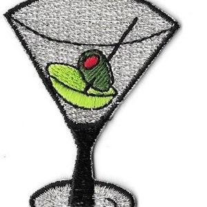 Peut inclure: Un verre à martini brodé argenté avec une olive verte et un centre rouge.