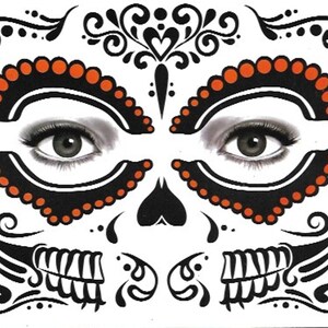 Op de afbeelding: Zwarte en oranje tijdelijke gezichts tatoeages met een Day of the Dead suiker schedel ontwerp. De tatoeages hebben ingewikkelde swirls, harten en stippen.