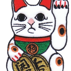 May include: White ceramic Maneki-Neko, or lucky cat, with a raised paw, green collar, and gold coin. The cat is holding a gold coin with Japanese characters.