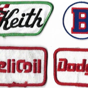Peut inclure: Quatre patchs brodés en rouge, blanc et bleu. Les patchs présentent les noms "Keith", "Dodge", "Helicoil" et une lettre "B" dans un cercle.