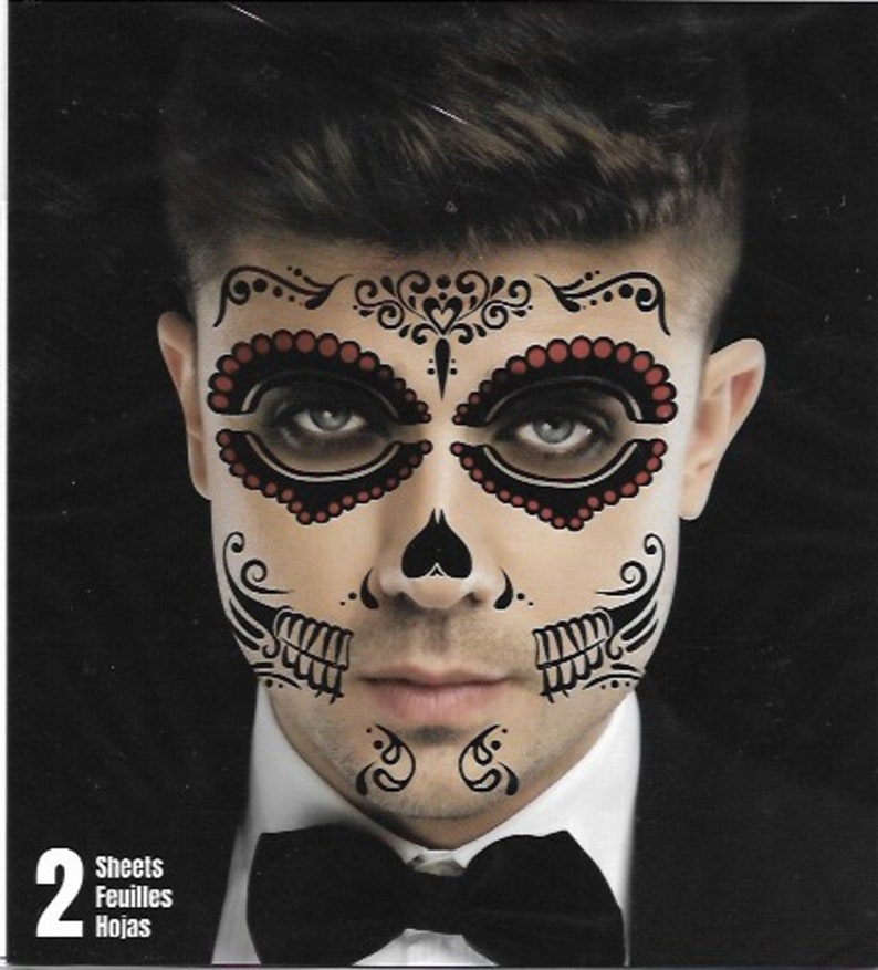 Op de afbeelding: Twee vellen tijdelijke gezichts tatoeages met een zwart en rood Day of the Dead suiker schedel ontwerp. Het ontwerp bevat ingewikkelde details en een hartvorm op de neus.