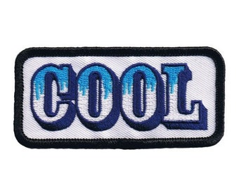 Pode incluir: Etiqueta bordada branca com um contorno azul e azul claro da palavra "COOL" em um tipo de letra em negrito.