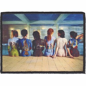 May include: A vintage-style embroidered patch featuring a group of seven people sitting in a row. The people are wearing a variety of clothing, including a blue shirt, a green shirt, a blue and white shirt, a black shirt, a blue shirt, a white shirt, and a red shirt. The patch is set against a background of a blue and white striped wall.
