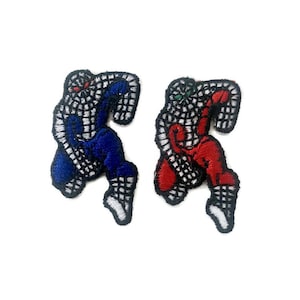 Könnte beinhalten: Zwei gestickte Bügelbilder mit einer Cartoon-Figur in einem weißen, schwarzen und blauen oder roten Anzug. Die Figur rennt und hat einen schwarzen Umriss.