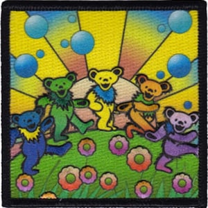 Può includere: Cinque orsi di cartoni animati colorati con facce sorridenti stanno in un campo di erba verde e fiori. Gli orsi indossano magliette e pantaloni di diversi colori. Lo sfondo è un tramonto giallo e arancione con bolle blu.