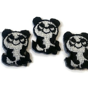 May include: Three black and white embroidered panda bear patches with sunglasses. The panda bears are smiling and have a black outline.