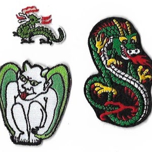 Könnte beinhalten: Drei gestickte Bügelbilder mit einem grünen Drachen, einem grünen Gargoyle mit Flügeln und einem grünen Drachen mit roten und gelben Akzenten.