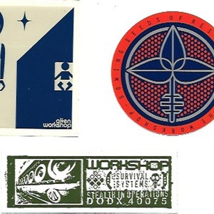 May include: A collection of three stickers. One features an alien figure and the text "alien workshop". Another is a circular design with the text "Sowing Seeds of Resistance - The Workshop". The third sticker has the text "WORKSHOP SURVIVAL SYSTEMS STEALTH IN OPERATIONS DODX.40075".