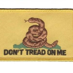 May include: A yellow embroidered patch featuring a coiled rattlesnake and the text "Don't Tread On Me".