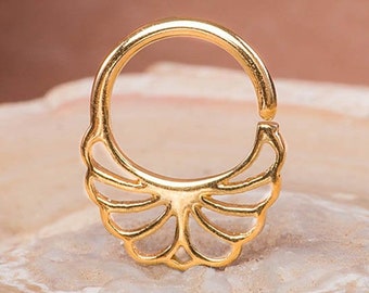 May include: Gold septum ring with a delicate, intricate, fan-shaped design. The ring is made of metal and has a smooth, polished finish.